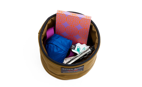 A Small Travel Tray holding a pack of cards, tube of hand-cream, chapstick, pocket travel pillow, key strap and keys.